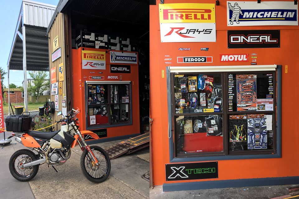 Motorcycle outside the Gloucester workshop, with Pirelli and Michelin signage